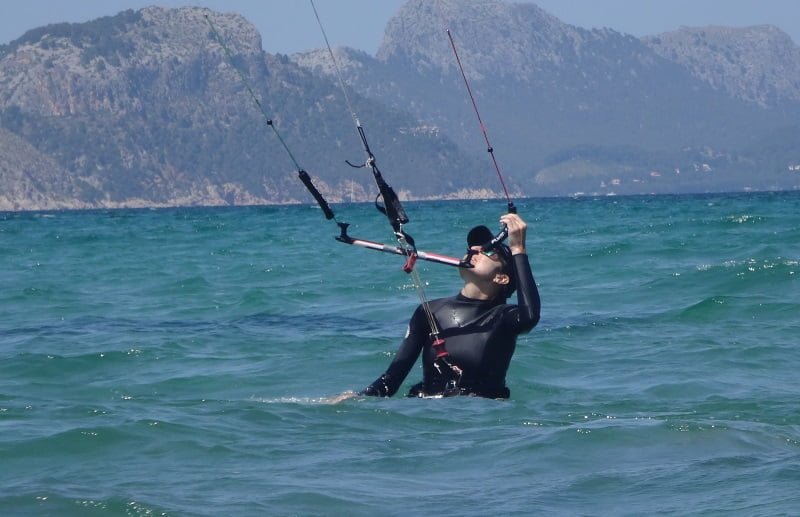 1 clases de kitesurf para niñas en Mallorca caminando hacia atrás manteniendo el control del kite